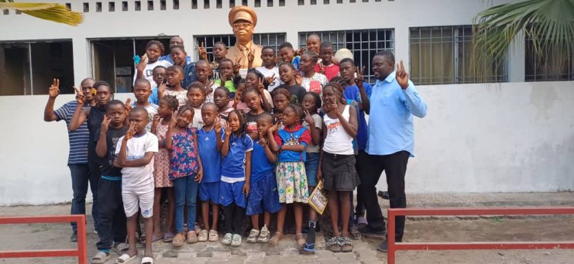 Les 35 enfants réunifiés en 2025, avec Yves Tungila, devant le buste de l'ancien président de la République, Joseph Kasavubu.